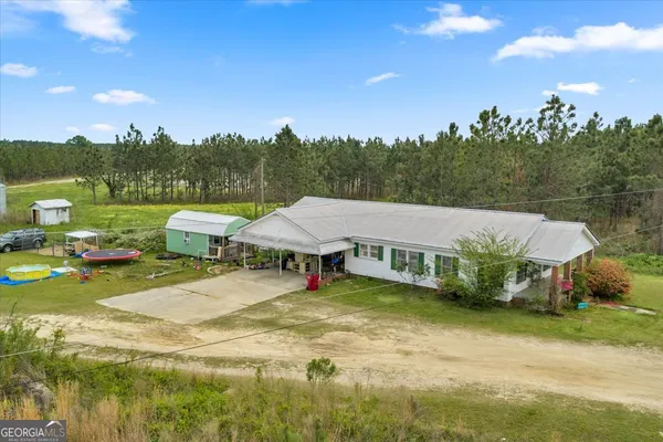 a view of a lake with lawn chairs and a fire pit