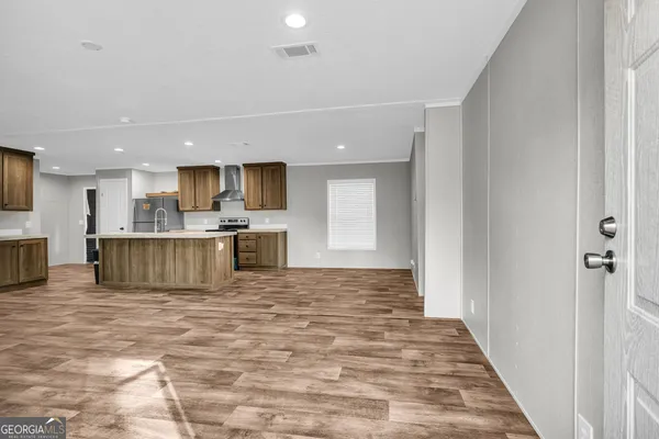 a view of empty room with window and wooden floor
