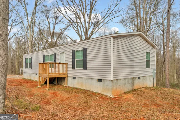 front view of a house with a yard and a wooden fence