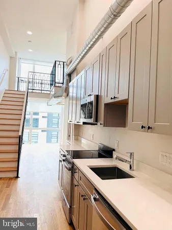 a kitchen with kitchen island granite countertop a sink and white cabinets
