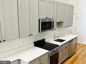 a kitchen with stainless steel appliances a stove a microwave and white cabinets