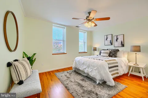 a bedroom with a bed a couch and potted plant on the table