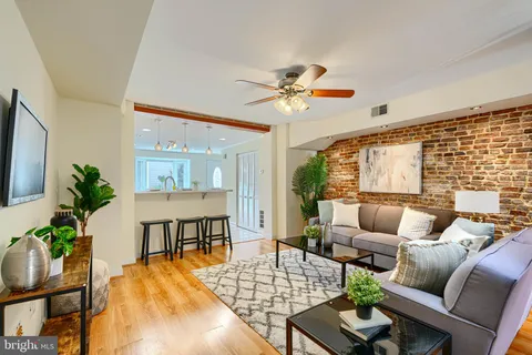 a living room with furniture wooden floor and a large window