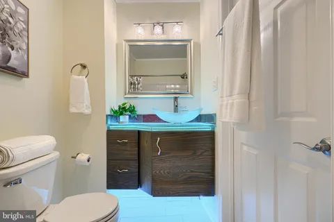 a bathroom with a sink vanity mirror and toilet