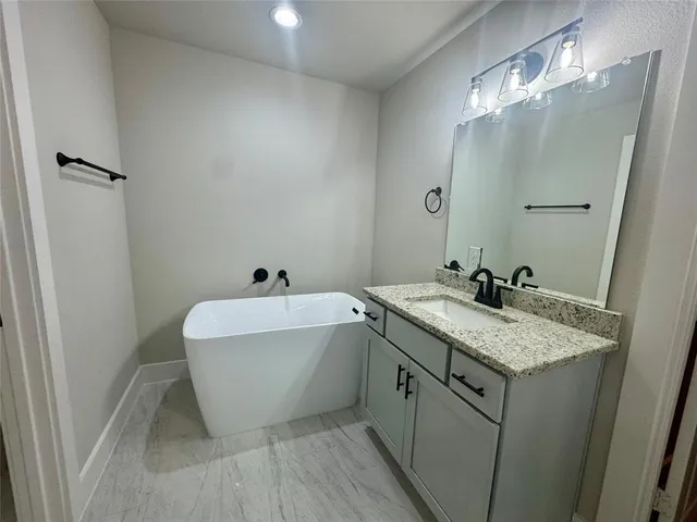 a bathroom with a tub sink and mirror