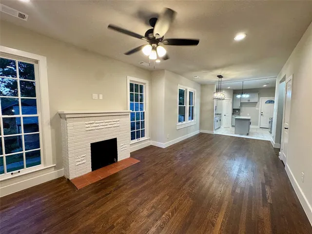 a view of an empty room with a fireplace and a window
