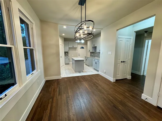 a view of a room with wooden floor and stainless steel appliances