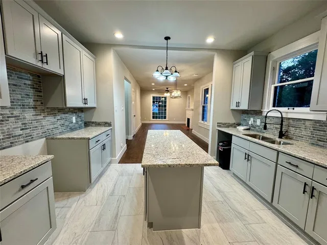 a large kitchen with stainless steel appliances granite countertop plenty wooden cabinets counter space a sink and a stove