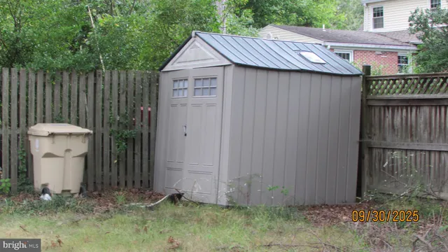a view of a small house with wooden fence