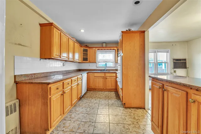 a kitchen with stainless steel appliances granite countertop a refrigerator a sink dishwasher and wooden cabinets with wooden floor