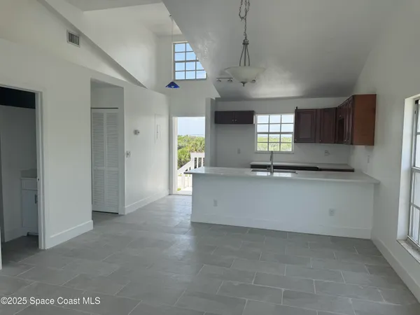 a large white kitchen with granite countertop a large window