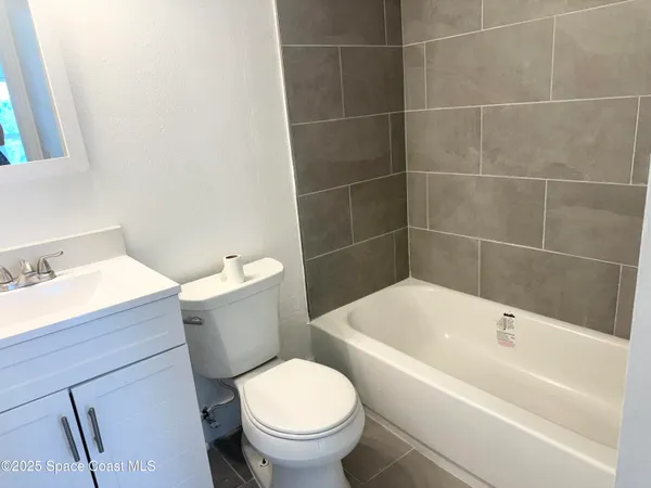 a white toilet sitting next to a bathroom sink and tub