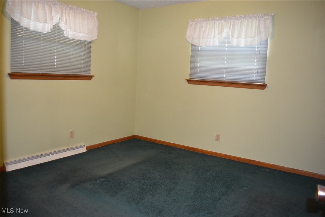 608 Gibbs Road Akron, OH 44312 - Photo 12 of 40 Empty room with a baseboard radiator and carpet floors