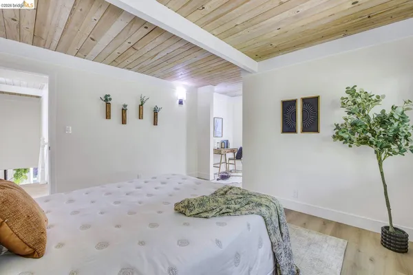 a bedroom with a bed and a potted plant