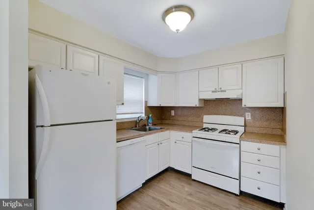 a kitchen with cabinets appliances a sink and a counter space