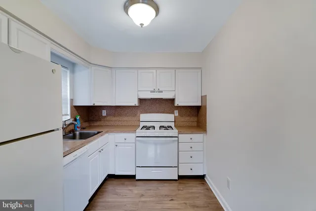 a kitchen with white cabinets and white appliances