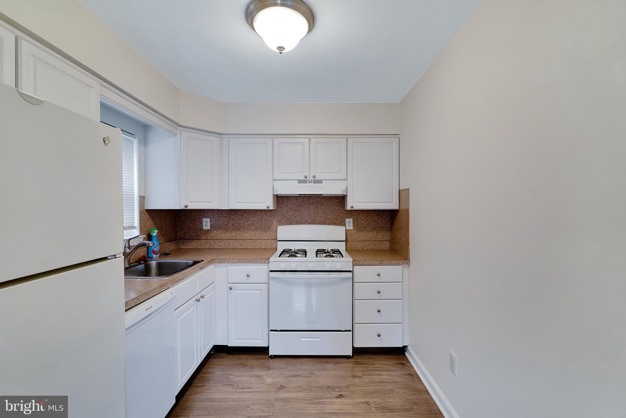 9754 East Roosevelt Boulevard, Unit 1 Philadelphia, PA 19115 - Photo 12 of 30 a kitchen with white cabinets and white appliances