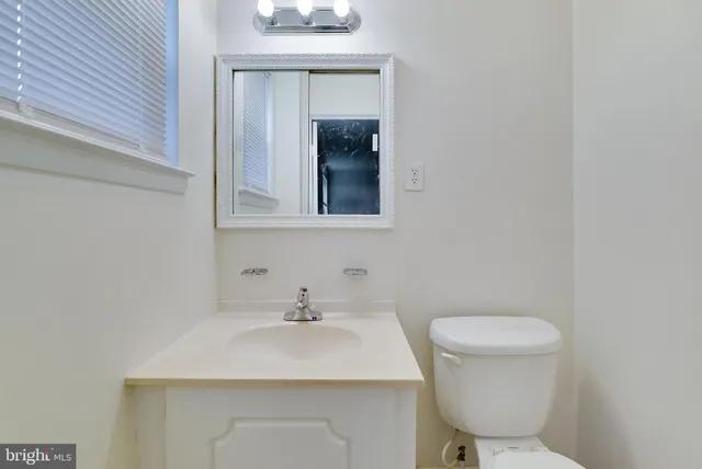 a bathroom with a toilet a sink and mirror