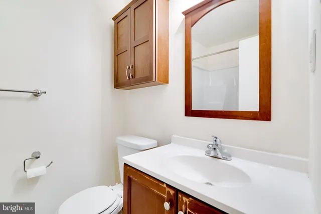 a bathroom with a sink vanity mirror and toilet
