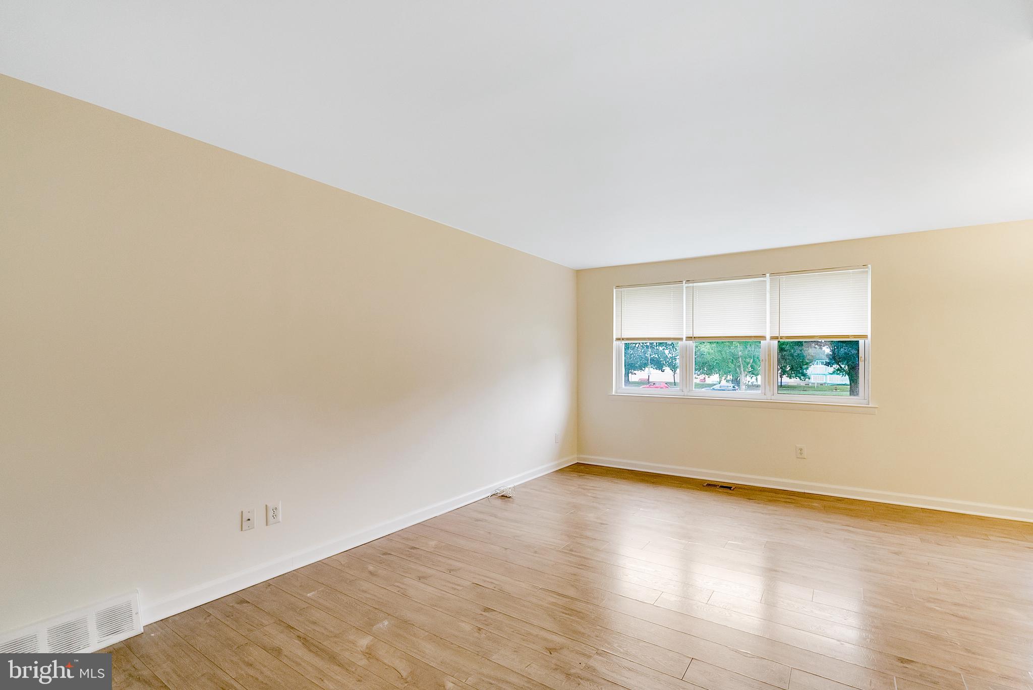 9754 East Roosevelt Boulevard, Unit 1 Philadelphia, PA 19115 - Photo 4 of 30 an empty room with wooden floor and windows