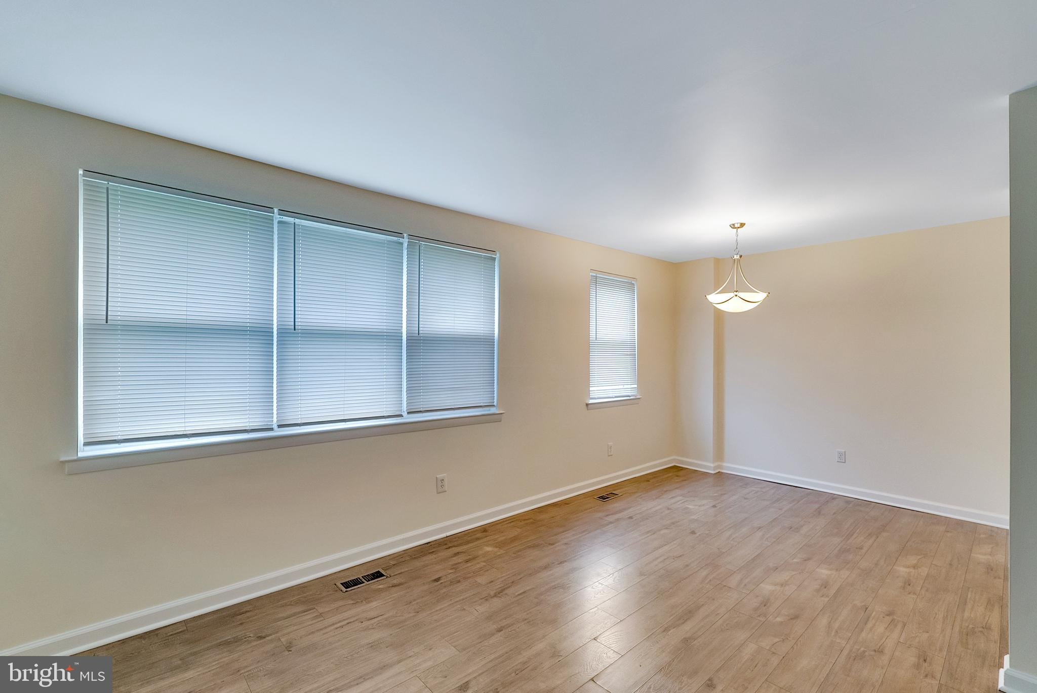 9754 East Roosevelt Boulevard, Unit 1 Philadelphia, PA 19115 - Photo 8 of 30 an empty room with wooden floor and windows