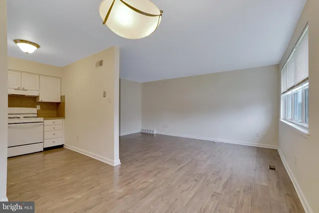 a view of a kitchen with wooden floor and electronic appliances