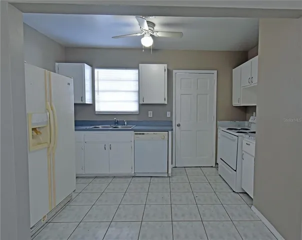 a kitchen with a sink a refrigerator and cabinets