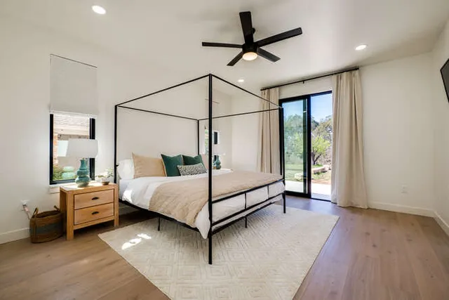 a bedroom with a bed chandelier and a window