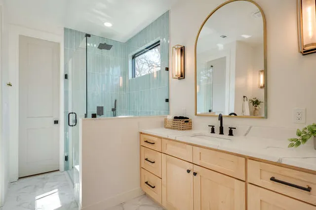 a bathroom with a granite countertop sink mirror and shower