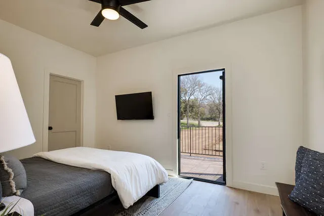 a bedroom with a bed a flat screen tv and view
