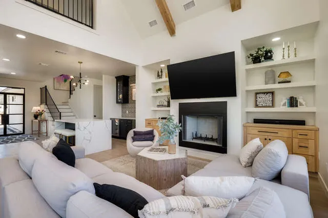 a living room with furniture a flat screen tv and a fireplace