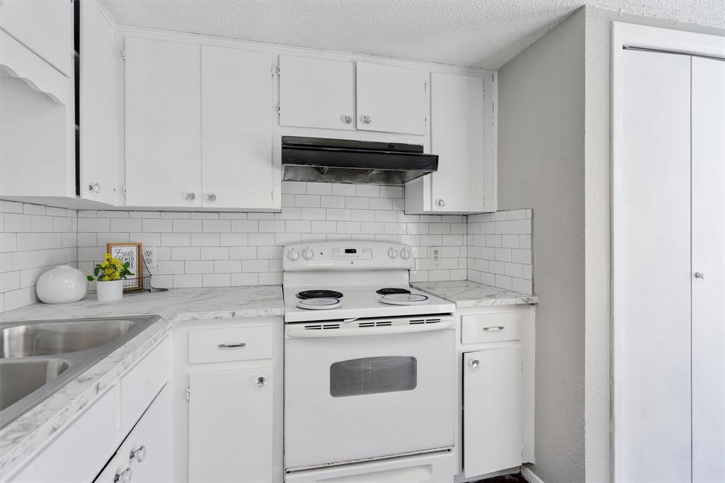 1711 Rawhide Loop Round Rock, TX 78681 - Photo 5 of 14 Kitchen featuring white range with electric cooktop, light countertops, white cabinetry, under cabinet range hood, and tasteful backsplash