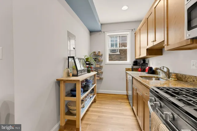 a kitchen with stainless steel appliances granite countertop a sink and a stove
