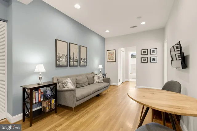 a living room with furniture and a wooden floor