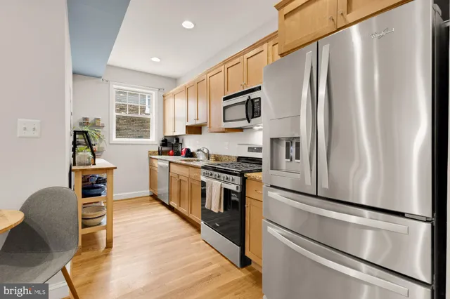 a kitchen with stainless steel appliances granite countertop a stove microwave and sink
