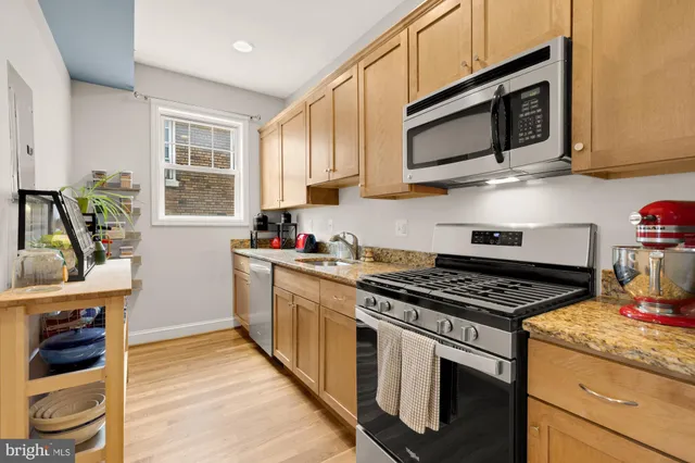 a kitchen with stainless steel appliances a stove a sink and a microwave
