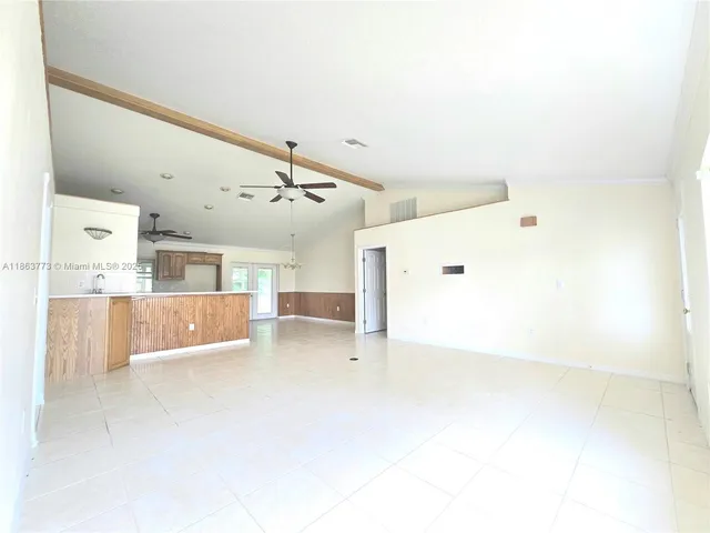a view of a kitchen with kitchen island and stainless steel appliances