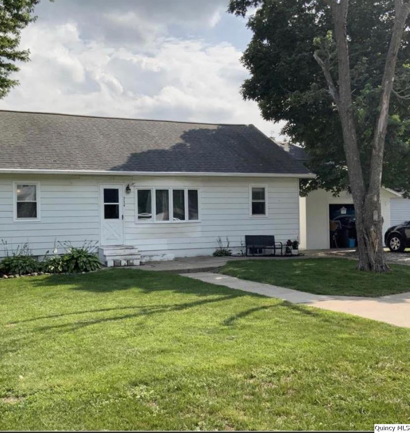 a view of a house with a yard patio and a tree