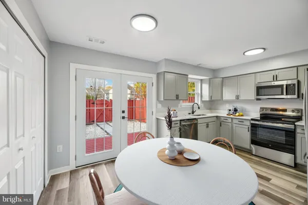a kitchen with stainless steel appliances a dining table and chairs