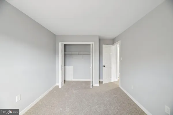 a view of an empty room and closet area
