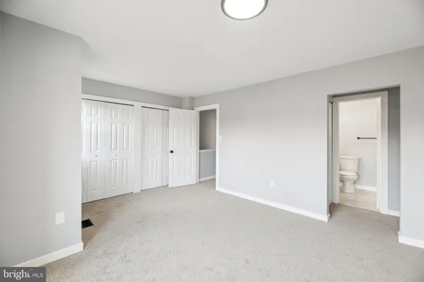 a view of an empty room and a bathroom