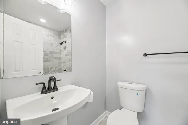 a bathroom with a sink a toilet and mirror