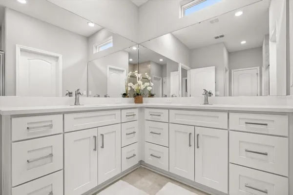 a bathroom with double sink and a mirror