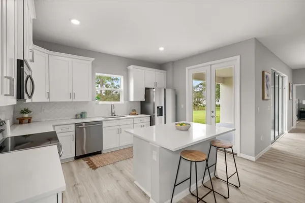 a kitchen with a dining table chairs and refrigerator