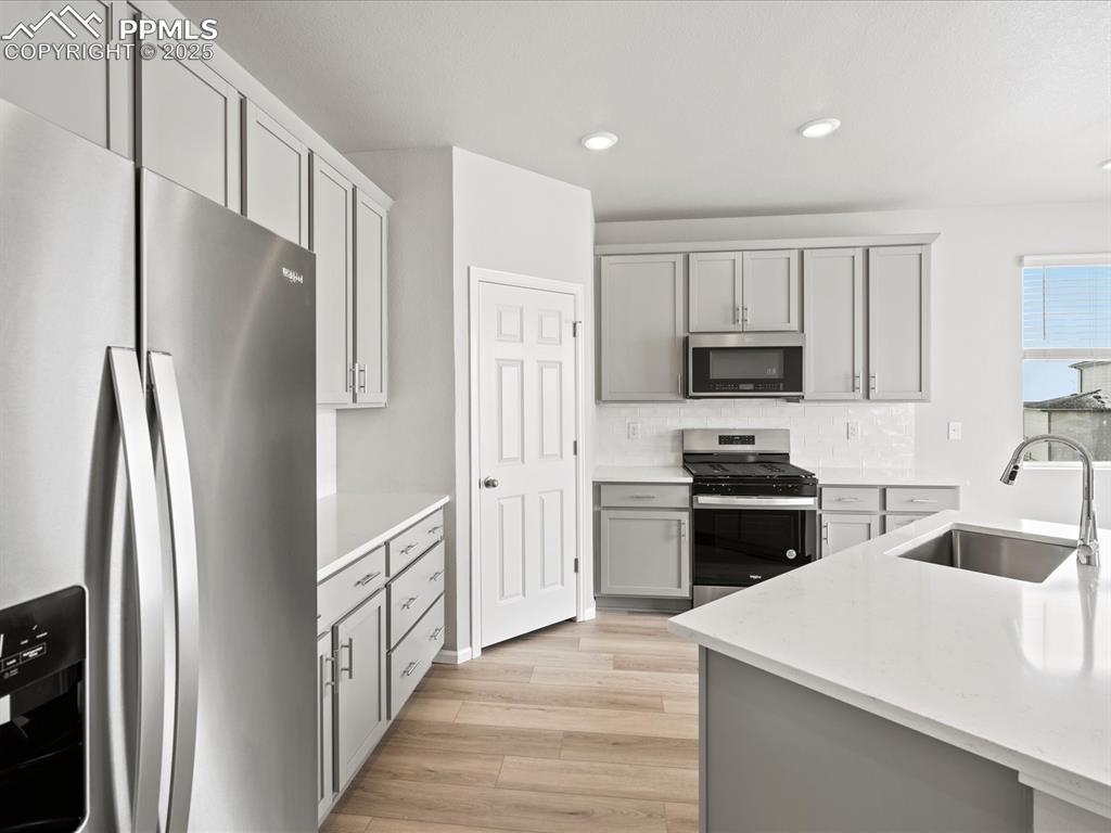 10434 Devoncove Drive Peyton, CO 80831 - Photo 4 of 24 a kitchen with white cabinets and stainless steel appliances