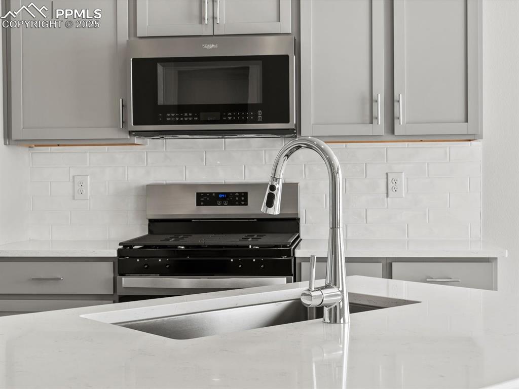 10434 Devoncove Drive Peyton, CO 80831 - Photo 5 of 24 a kitchen with stainless steel appliances granite countertop a stove and a microwave