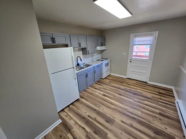 a kitchen with a refrigerator and white cabinets