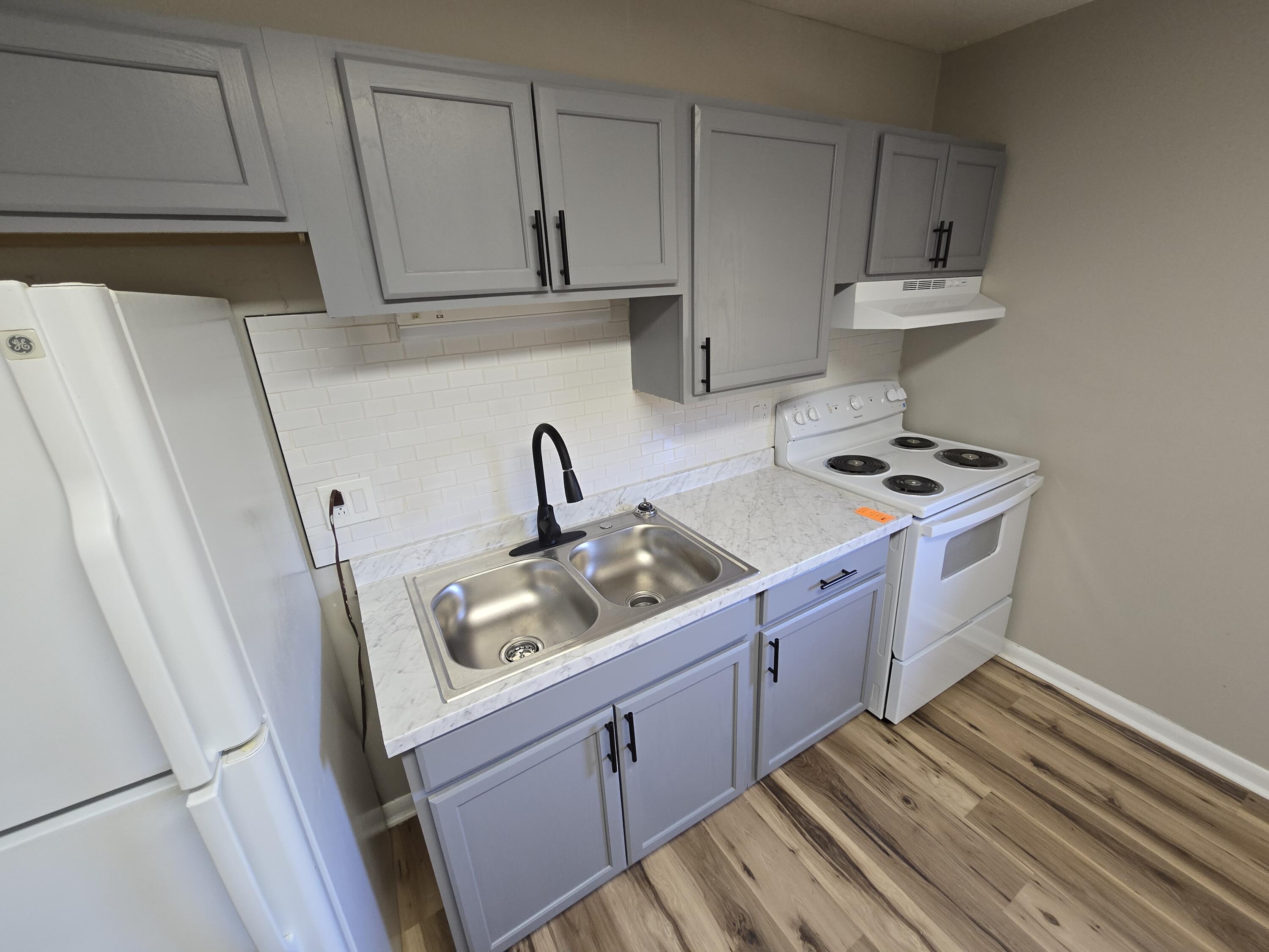 1301 Burks Street Southwest, Unit 204 Roanoke, VA 24015 - Photo 4 of 7 a kitchen with sink a stove and cabinets