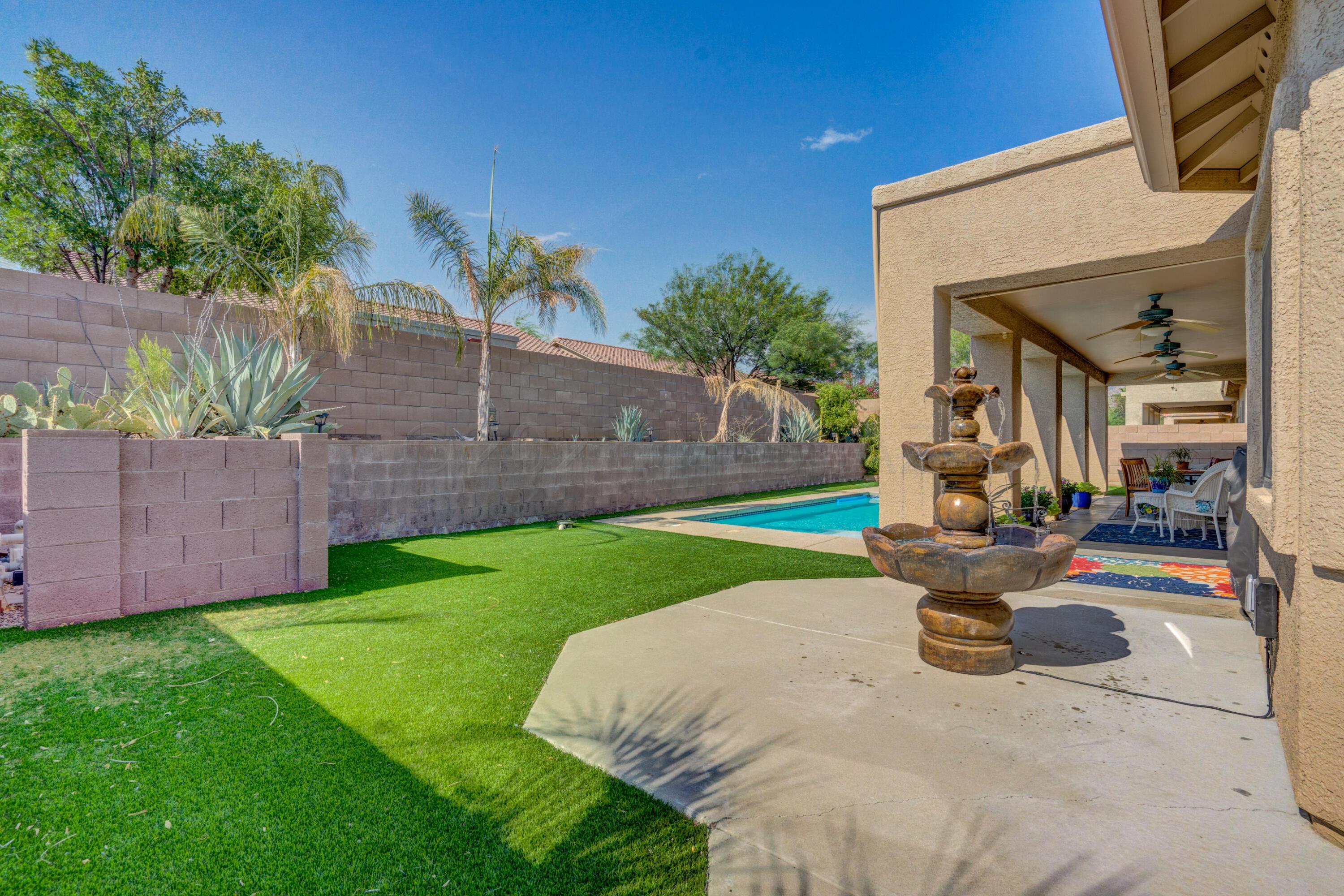 3639 East Northern Dancer Road Tucson, AZ 85739 - Photo 46 of 48 a view of a backyard with table and chairs and potted plants