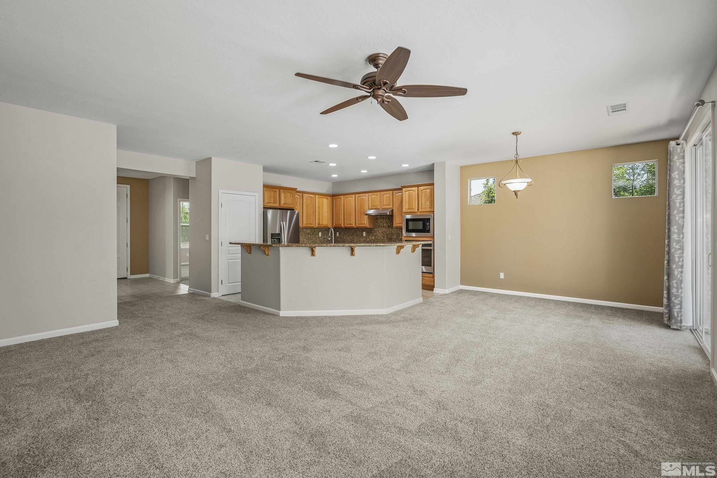 9195 Heritage Ridge Court Reno, NV 89523 - Photo 5 of 30 a view of a livingroom with a ceiling fan & kitchen view